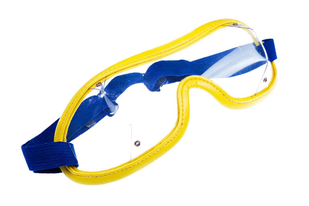 Blue and yellow skydiving goggles on white background.