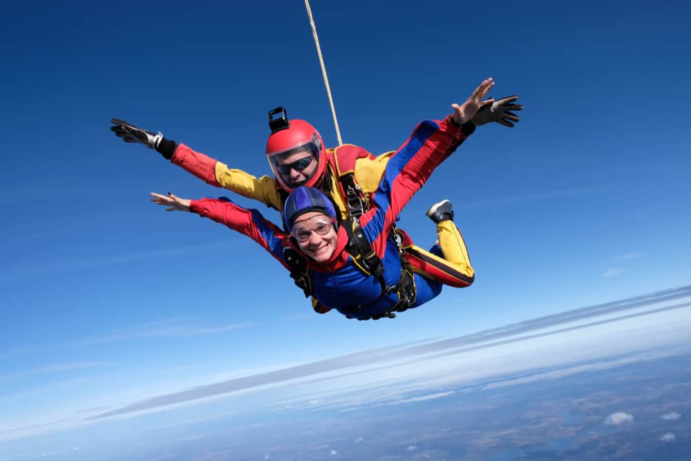 A male instructor with girl in the air in a tandem skydive jump.