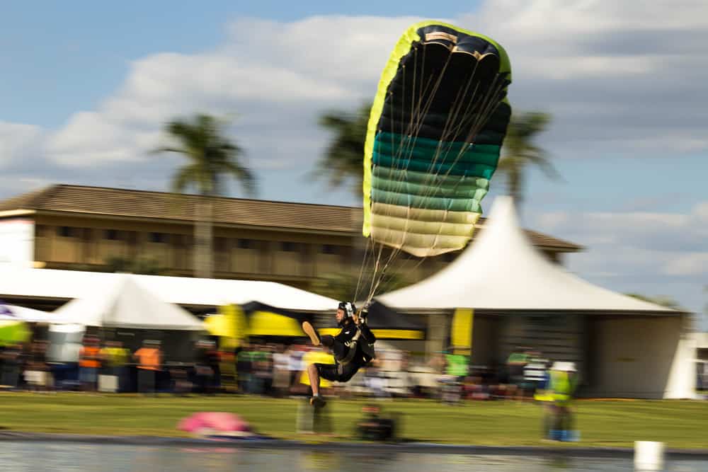 Skydiver swooping on pond in a competition.